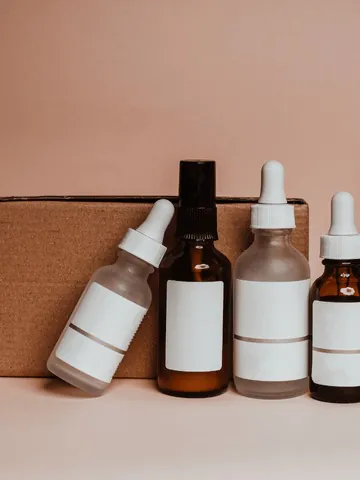 Glass dropper bottles of serum beside a delivery box